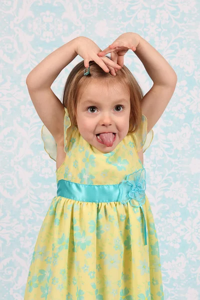 Adorable little girl making funny faces in studio — Stock Photo, Image