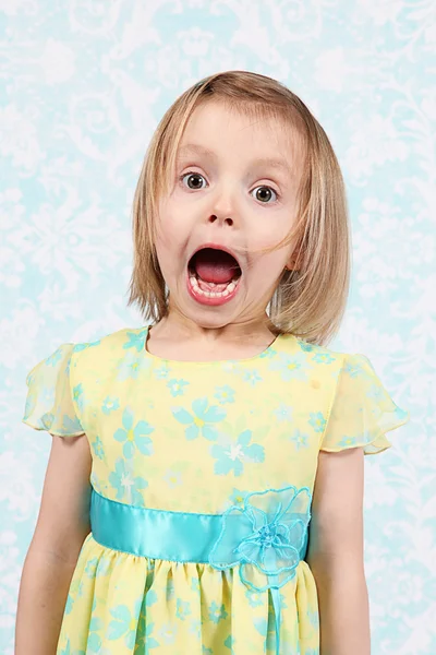 Чарівна маленька дівчинка робить смішні обличчя в студії — стокове фото