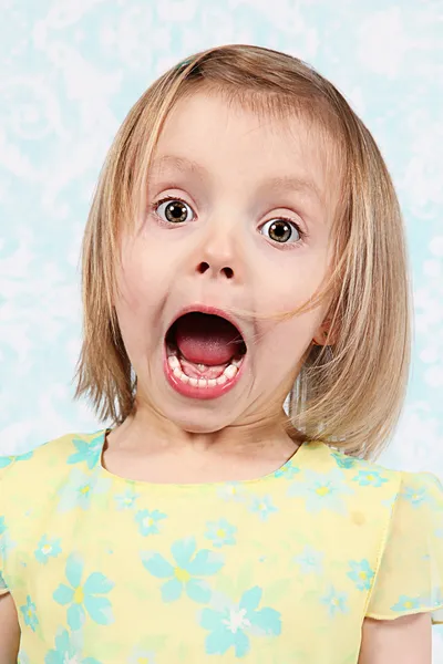 Очаровательная маленькая девочка строит смешные рожи в студии — стоковое фото