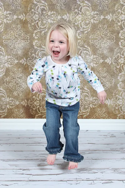 Entzückendes kleines Mädchen springt im Studio in die Luft — Stockfoto