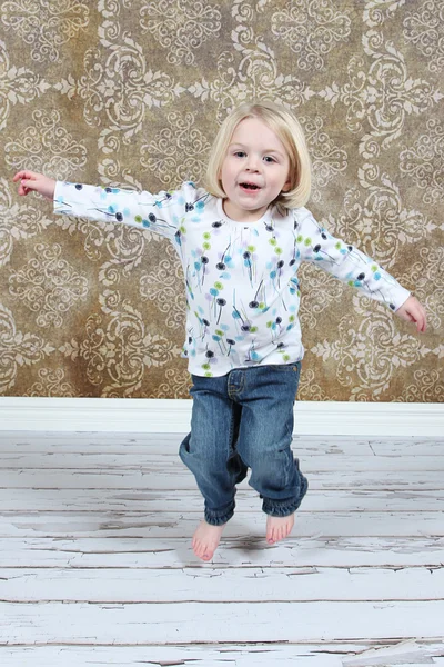 Adorable little girl jumping in air in studio — Stock Photo, Image