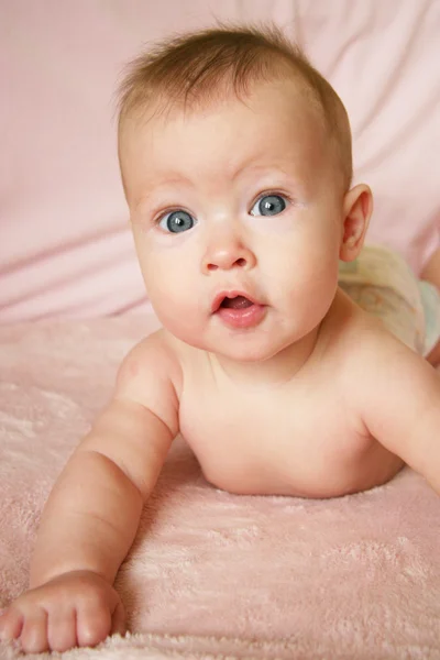 Baby flicka på hennes mage — Stockfoto