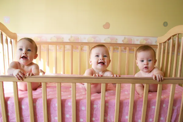 Девочки в кроватке - тройняшки — стоковое фото