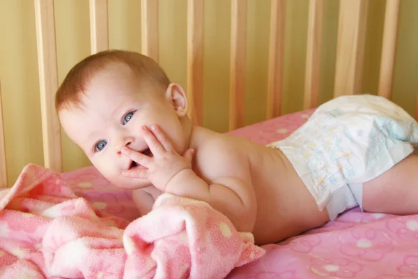 Baby Girl in Crib with hand to face — Stock Photo, Image