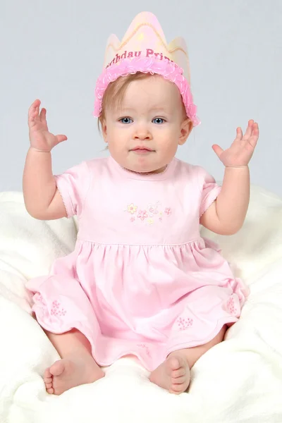 Bebé con sombrero de cumpleaños y la mano en el aire — Foto de Stock