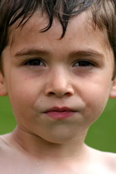 Menino levado close-up com água no rosto — Fotografia de Stock