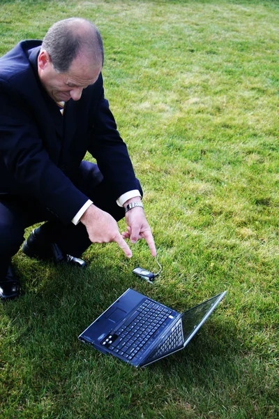 Hombre de negocios apuntando al ordenador portátil —  Fotos de Stock