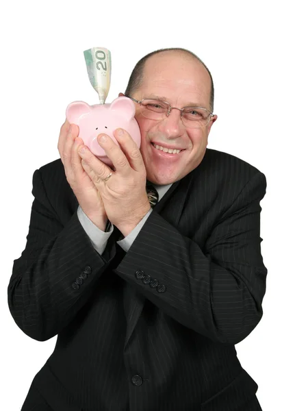 Бизнесмен обнимает свинью-банк — стоковое фото