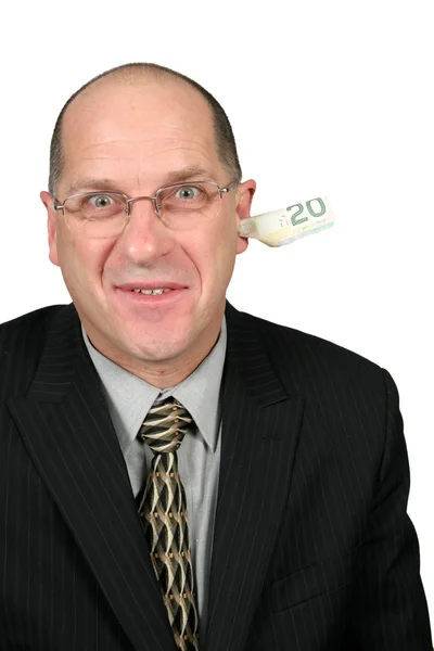 Бизнесмен с деньгами из уха — стоковое фото