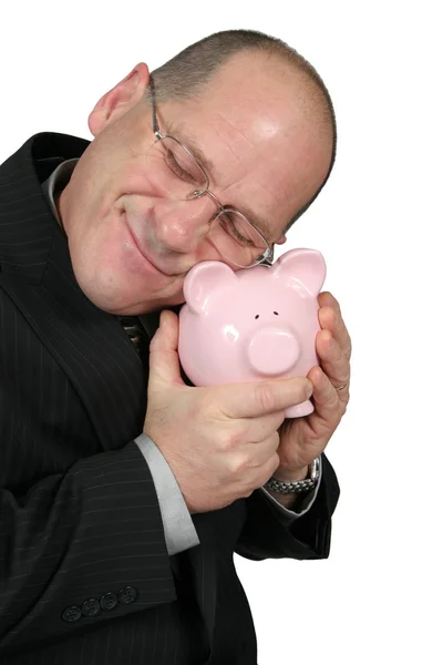 Бизнесмен обнимает свинью-банк — стоковое фото