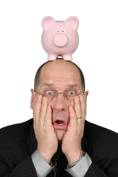 Деловой человек со свиным банком на голове и руками на лице — стоковое фото