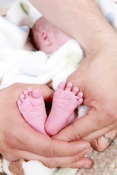 Bebés pies tomados de cerca en las manos — Foto de Stock
