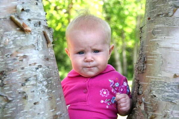 Baby flicka poserar av ett träd — Stockfoto