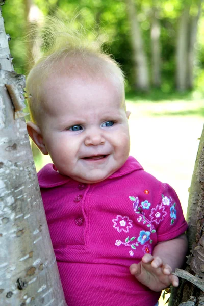 Baby flicka poserar bredvid trädet — Stockfoto