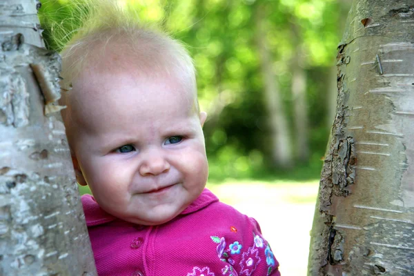 Meisje van de baby poseren in de bomen — Stockfoto