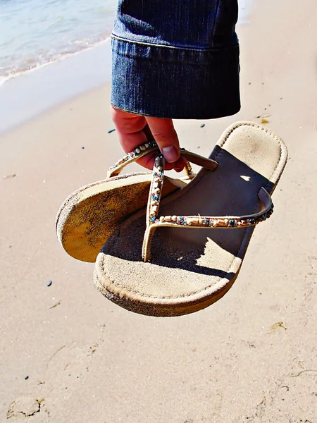 Mujer sosteniendo sandalias —  Fotos de Stock