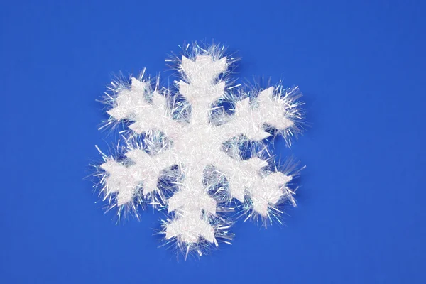 Biały płatek śniegu na niebieskim tle — Zdjęcie stockowe
