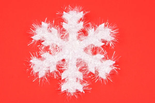 Biały płatek śniegu na czerwonym tle — Zdjęcie stockowe