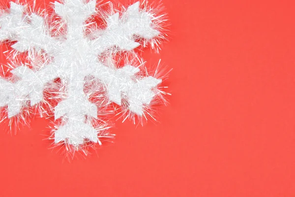 Weiße Schneeflocke auf rotem Hintergrund — Stockfoto