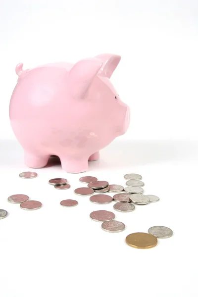 Roze piggy bank op wit met munten — Stockfoto