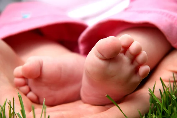 Bebé niña pequeños dedos de los pies en las manos madre — Foto de Stock