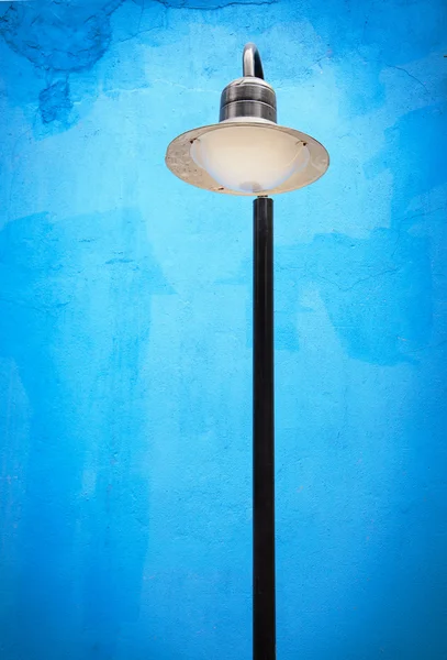 Rua lâmpada post contra fundo parede azul — Fotografia de Stock