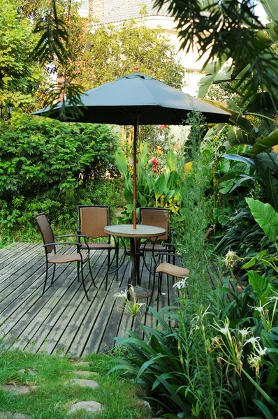 Bahçe Mobilyaları - rattan sandalye ve masa w şemsiyesi altında — Stok fotoğraf