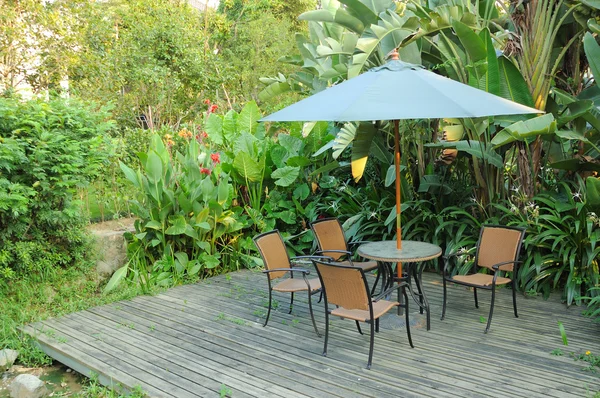 Mobili da giardino - sedie in rattan e tavolo sotto ombrellone su un w — Foto Stock