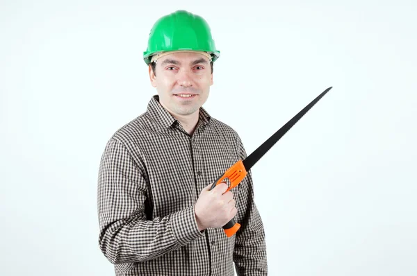 Man in protective helmet with a handsaw — Stock Photo, Image
