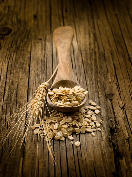 Spoon with oat on wood background — Stock Photo, Image