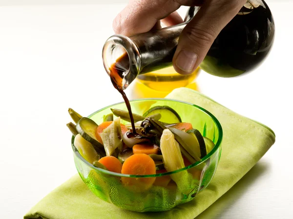 Versando aceto balsamico su insalata di verdure al vapore — Foto Stock