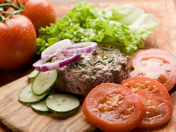 Hamburger with slice vegetables over cutting board — 스톡 사진