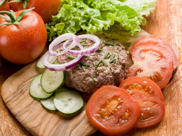 Hamburger con fetta di verdure sopra tagliere — Foto Stock