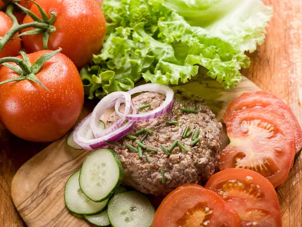 Hambúrguer com legumes de fatia sobre tábua de corte — Fotografia de Stock