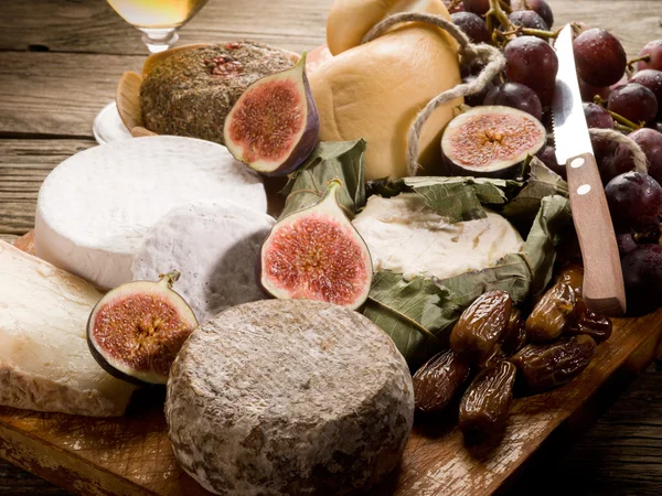 Tabla de quesos con una variedad de quesos y frutas —  Fotos de Stock