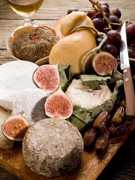 Planche à fromage avec un assortiment de fromages et de fruits — Photo