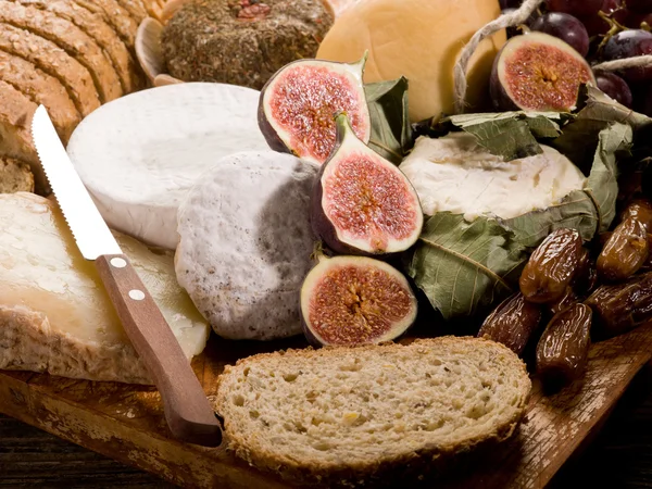 Scheibenbrot mit verschiedenen Käsesorten und Früchten — Stockfoto