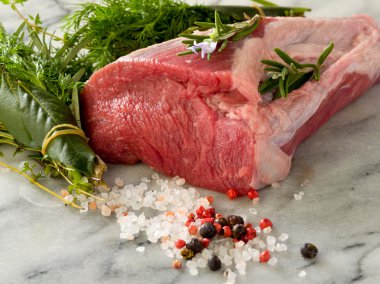 Raw tenderloin with mixed herbs juniper berry,pepper, salt clipart