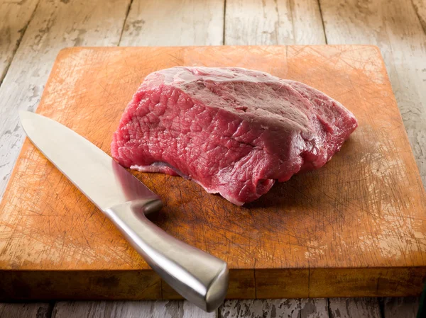 Eti bıçakla kesme tahtası üzerinde — Stok fotoğraf