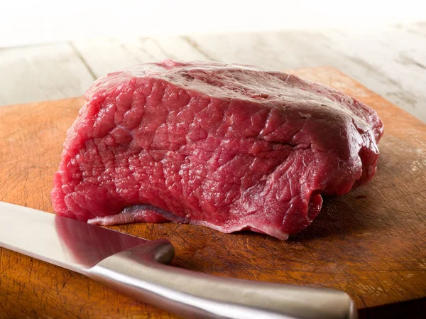 Mięso nożem nad deska do krojenia — Zdjęcie stockowe