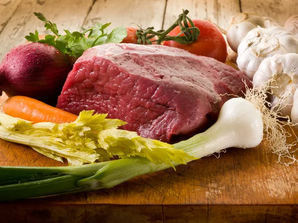 Maso s přísadami zeleniny přes prkénko — Stock fotografie