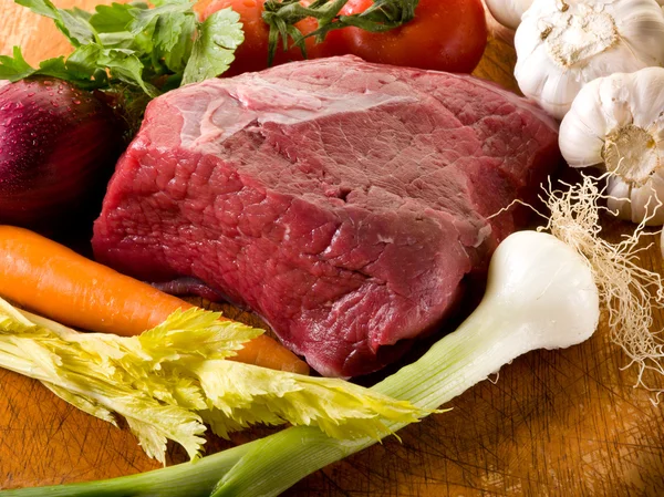 Fleisch mit Gemüsezutaten über Schneidebrett — Stockfoto