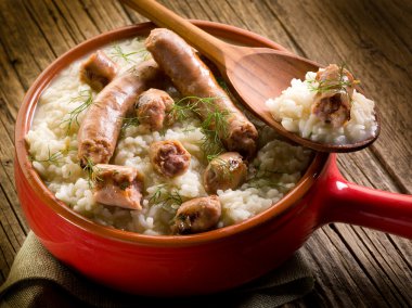 Risotto with sausage over red casserole clipart