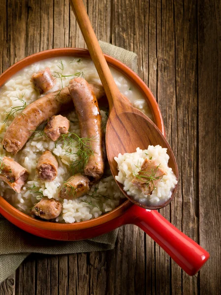Risotto with sausage over red casserole — Stock Photo, Image