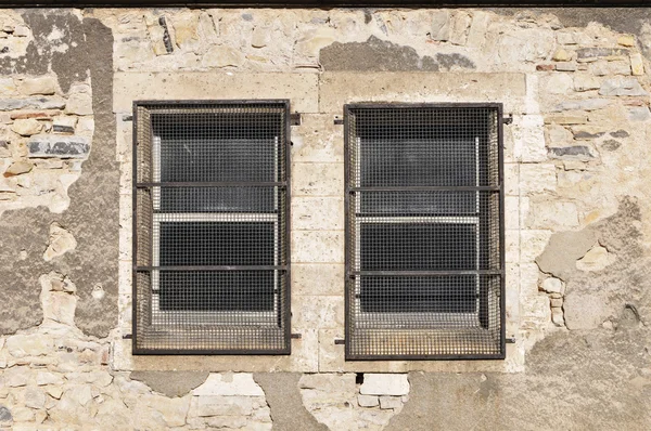 Zwei alte Fenster mit Metallgittern — Stockfoto