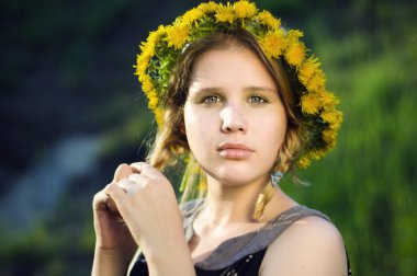 Dandelions kafasına bir çelenk ile güzel kız