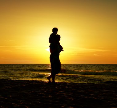 Çocuğun babası deniz günbatımı üzerinde