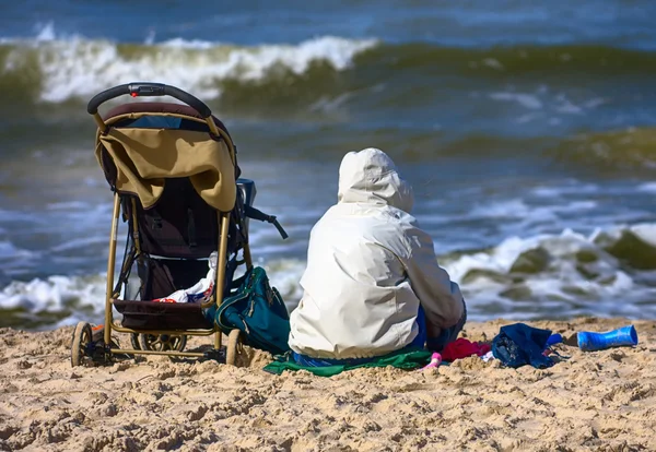 Mor och barnvagnar på stranden — Stockfoto