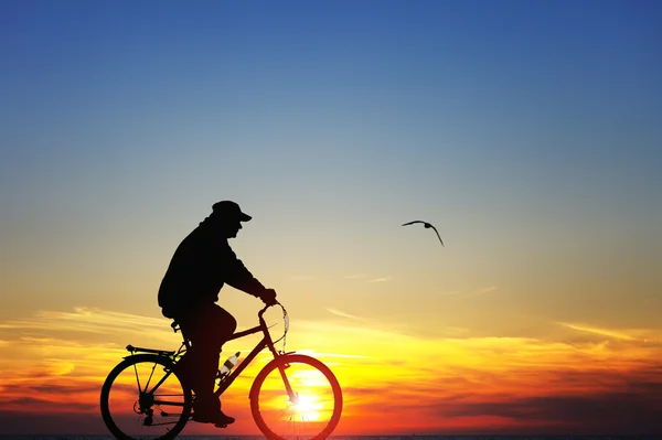 Silhouette eines Mannes auf dem Fahrrad bei Sonnenuntergang — Stockfoto
