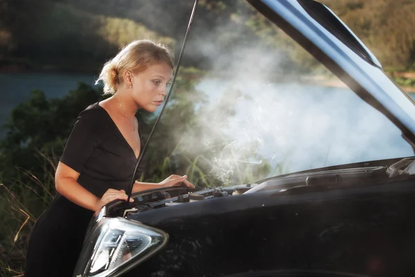 Portrait of young beautiful woman with broken car aside — Stock Photo, Image